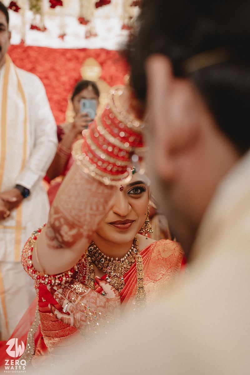 Close-up shots of traditional Indian bridal jewelry and attire in red and gold tones during a wedding ceremony.