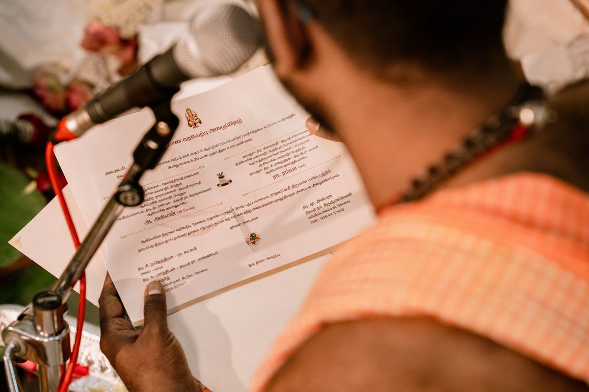 Hindu priest reading sacred wedding ceremony scriptures at a South Indian wedding ritual.