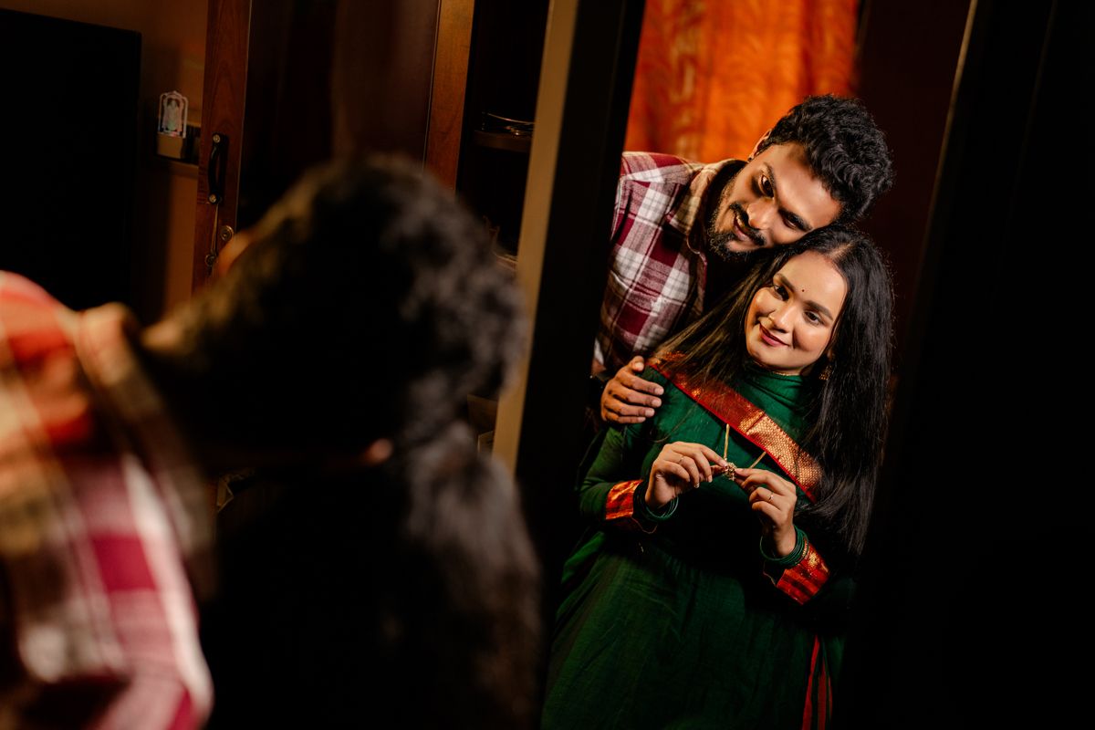 A joyful couple sharing a playful moment while looking in a mirror.