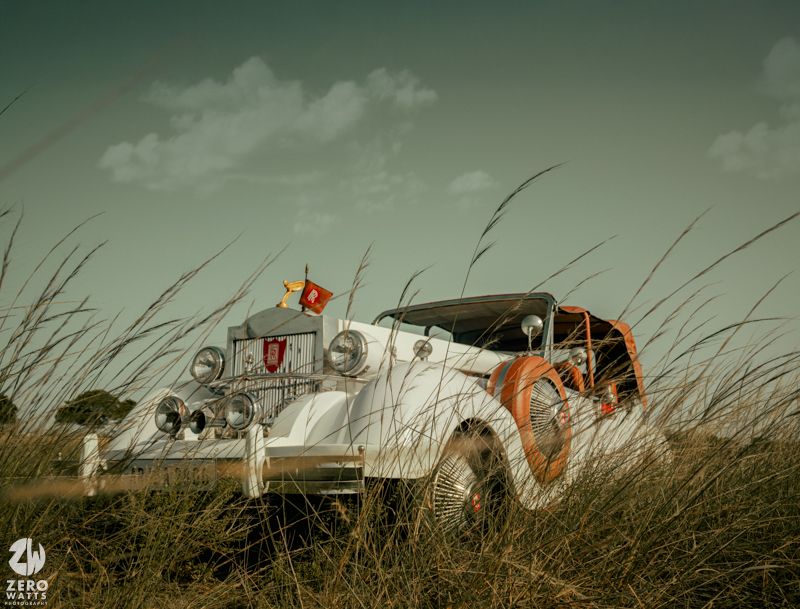 Vintage airstream trailers parked in tall grass under a moody green sky create a nostalgic camping scene.
