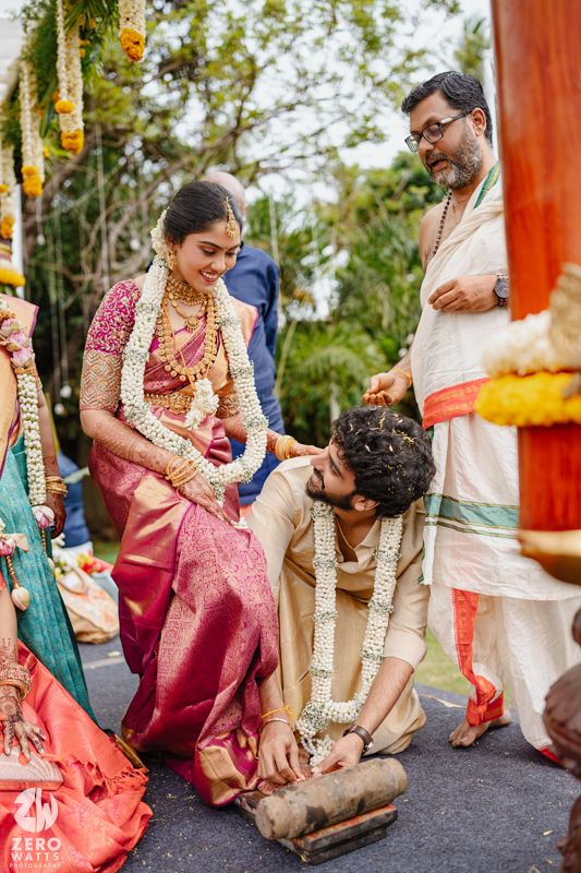 Traditional wedding ritual being performed with family members in silk sarees and traditional attire.