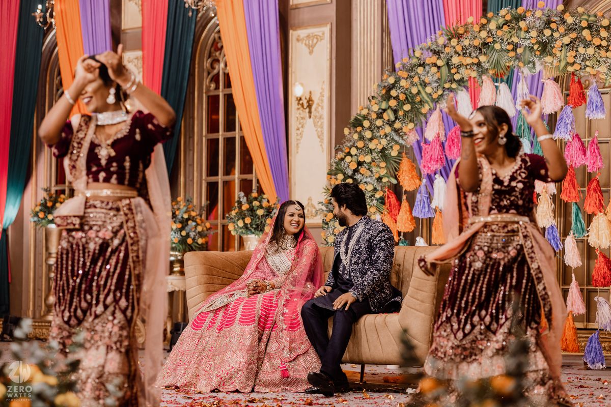 Wedding celebration scene with colorful decorations and floral arrangements in an elegant venue.