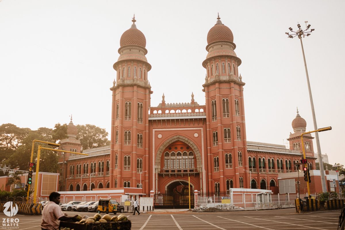 Majestic pink sandstone mosque with twin towers and arched entrance in golden sunlight.