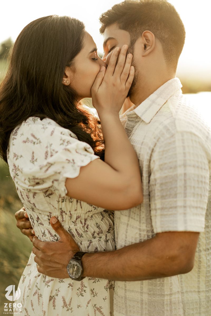Romantic couple sharing intimate moments in golden sunlight against a natural outdoor backdrop.