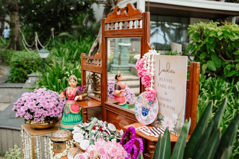 Wedding reception table decorated with pink flowers, candles and rustic wooden details in an outdoor garden setting.
