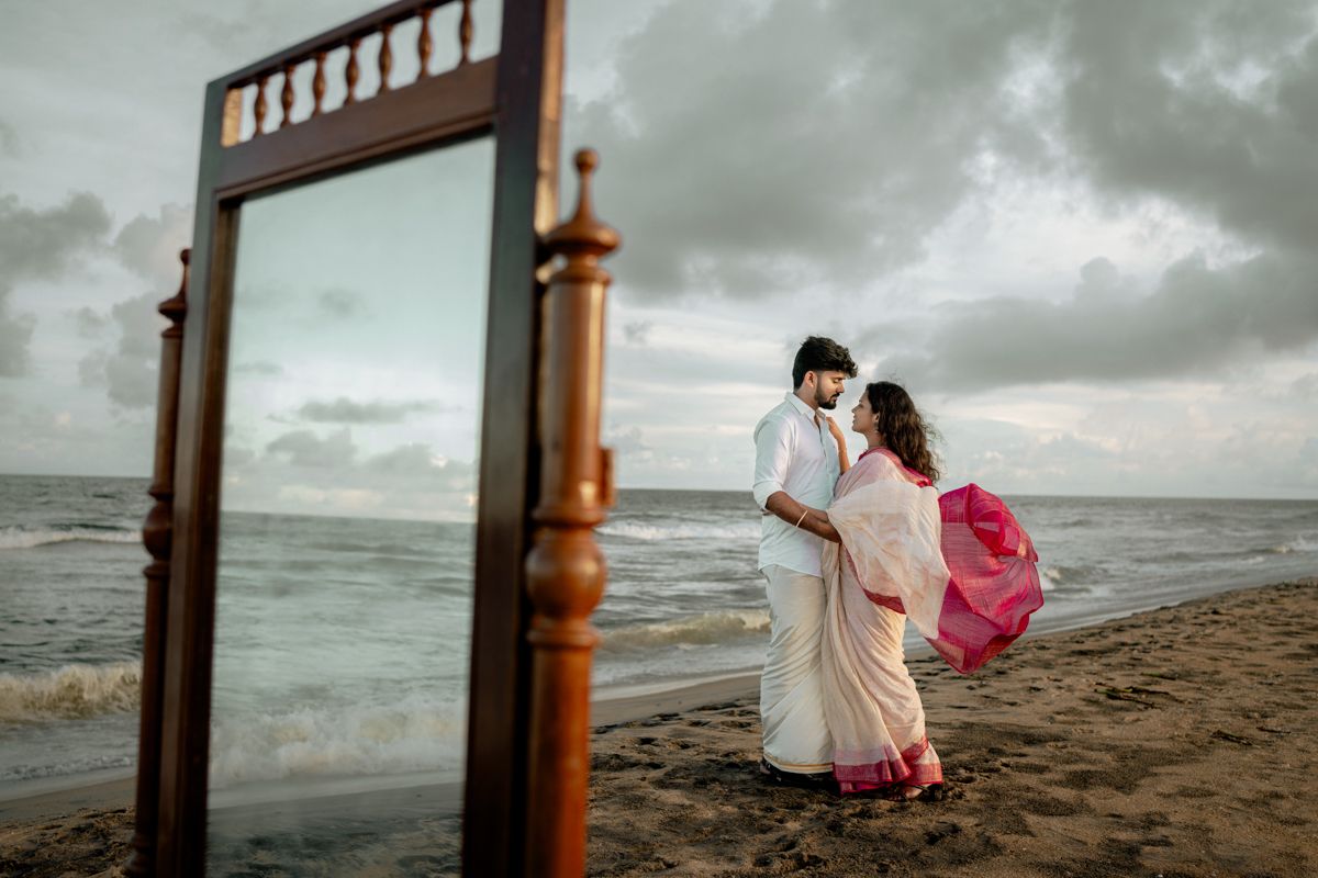 Atmospheric beach photography setup with vintage props and decorative elements against cloudy seaside backdrop.