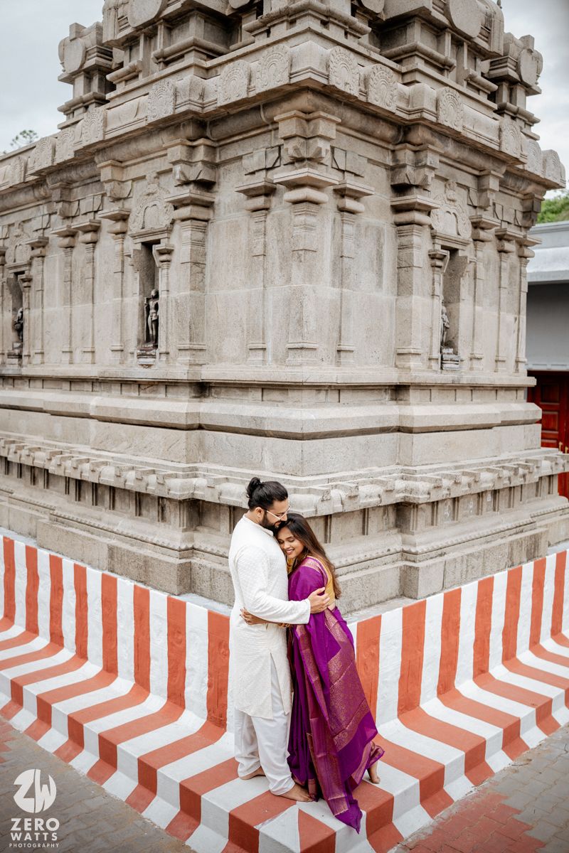 Temple exterior featuring striking red and white striped painted base against stone architecture.