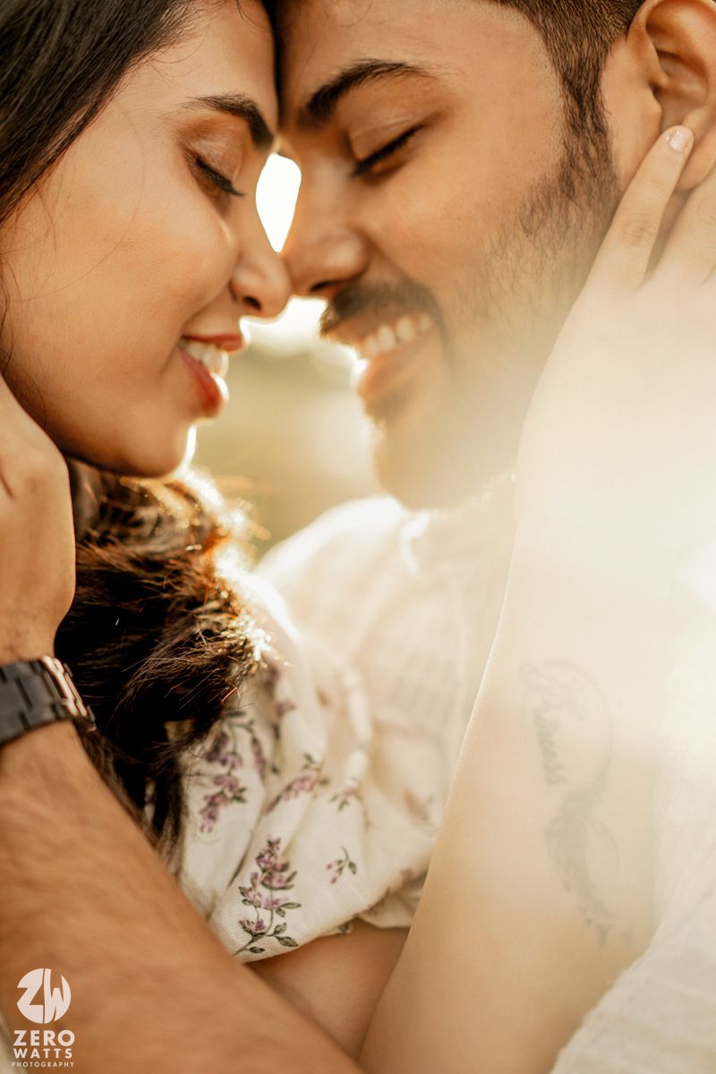 Romantic couple in warm lighting share intimate moments while wearing white and floral outfits.