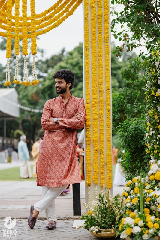 Traditional wedding decor features bright marigold garlands and yellow floral arrangements against lush greenery.