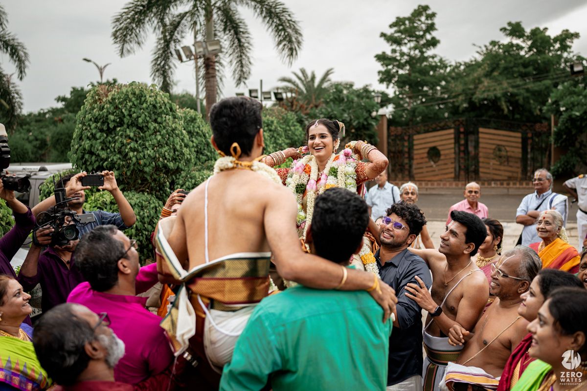 Festive crowd celebrating at an outdoor event with energetic dancing and colorful attire.