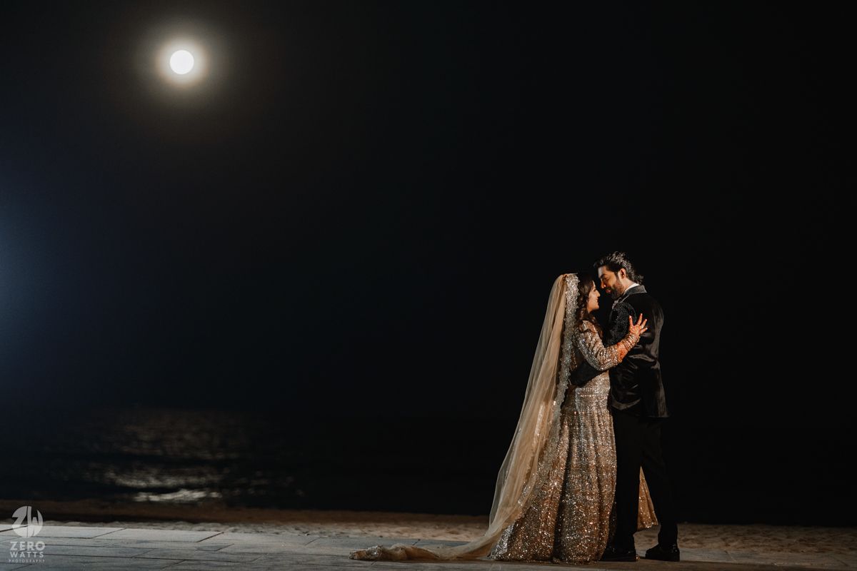 Romantic nighttime portrait with a full moon glowing in the dark sky above.