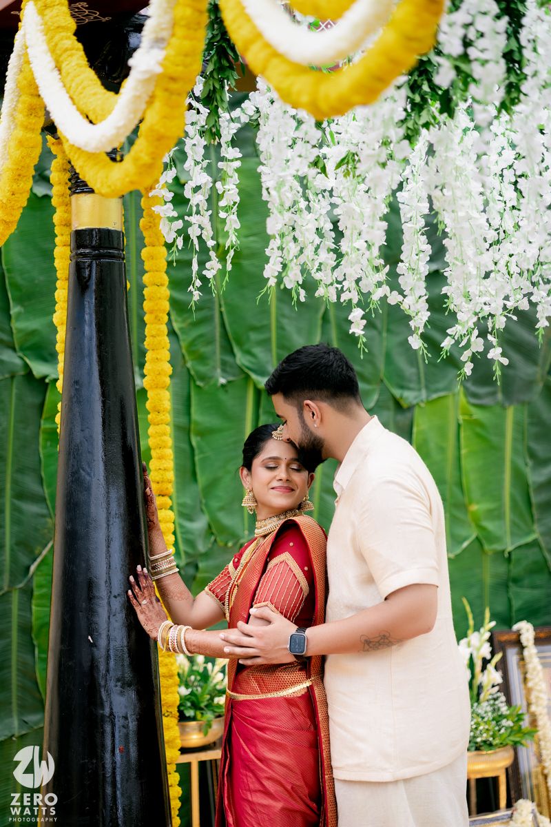 Intimate moment captured during a wedding ceremony under yellow and white floral decorations.