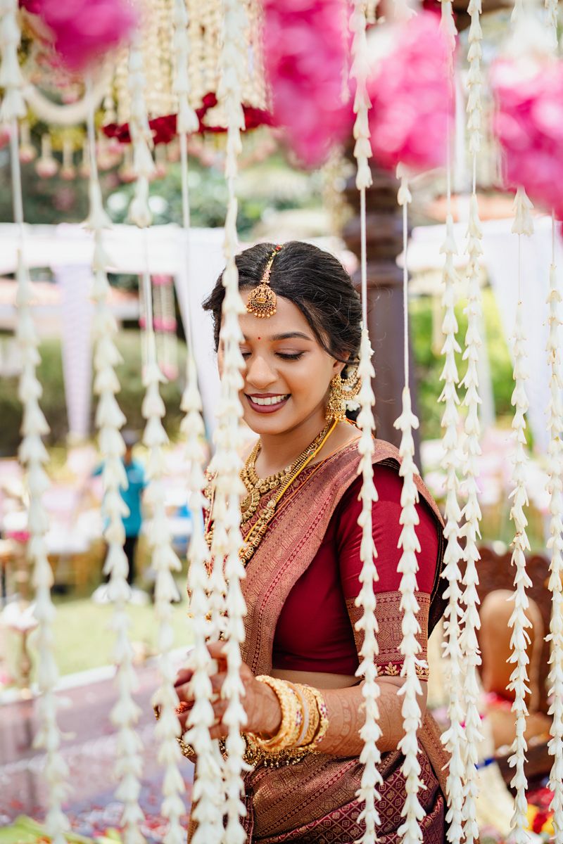 Traditional wedding ceremony with hanging floral decorations and pink accents.