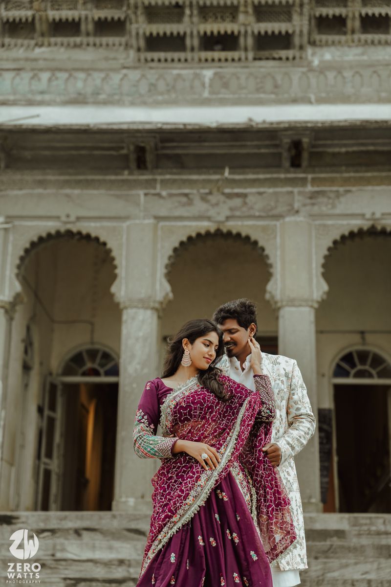 Intimate wedding portraits captured in front of a colonial-style palace with arched corridors.