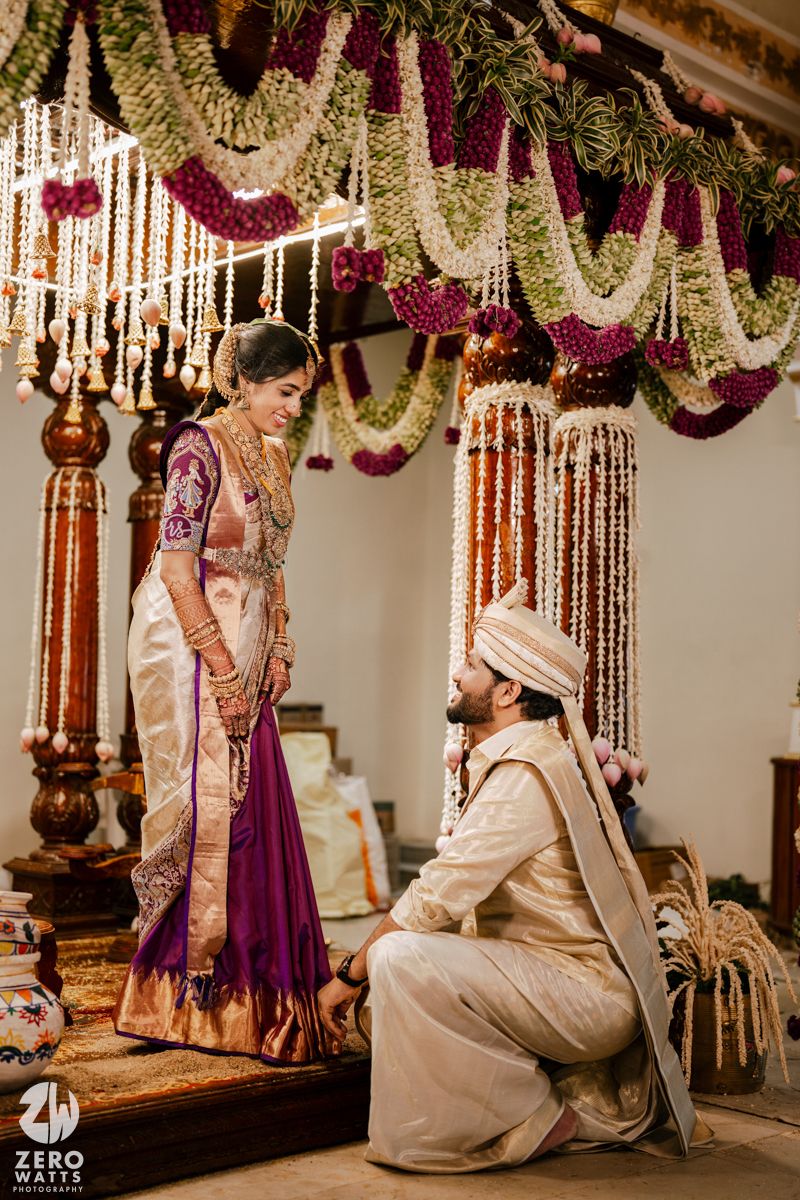 Traditional wedding ceremony setup with ornate floral garlands and wooden pillars.