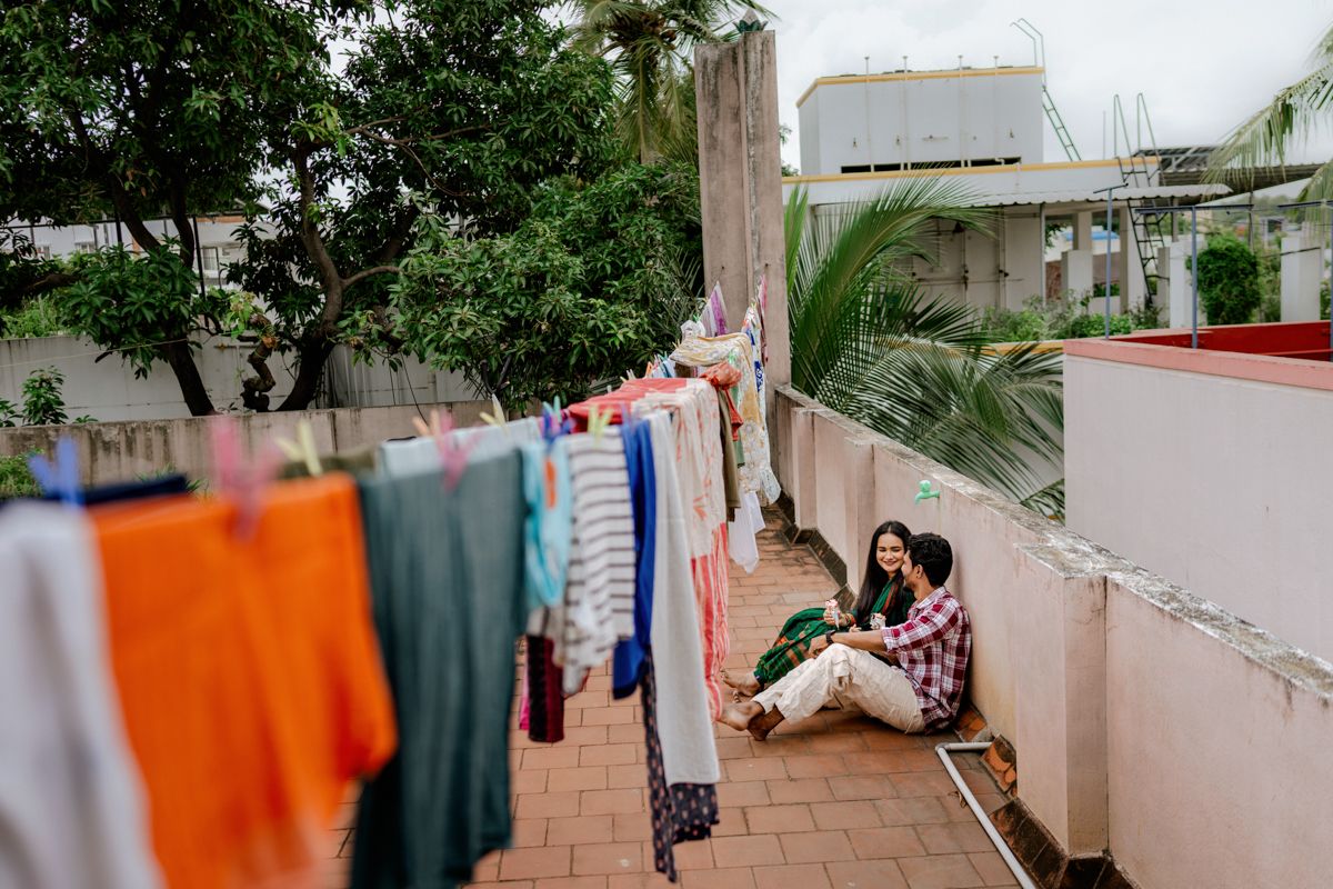 Colorful laundry hanging on clotheslines between buildings in an urban residential setting.