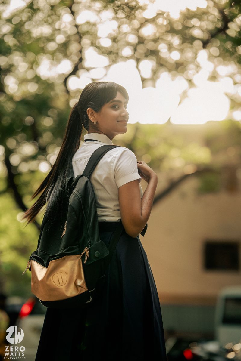 Student wearing backpack walking through campus during golden hour.