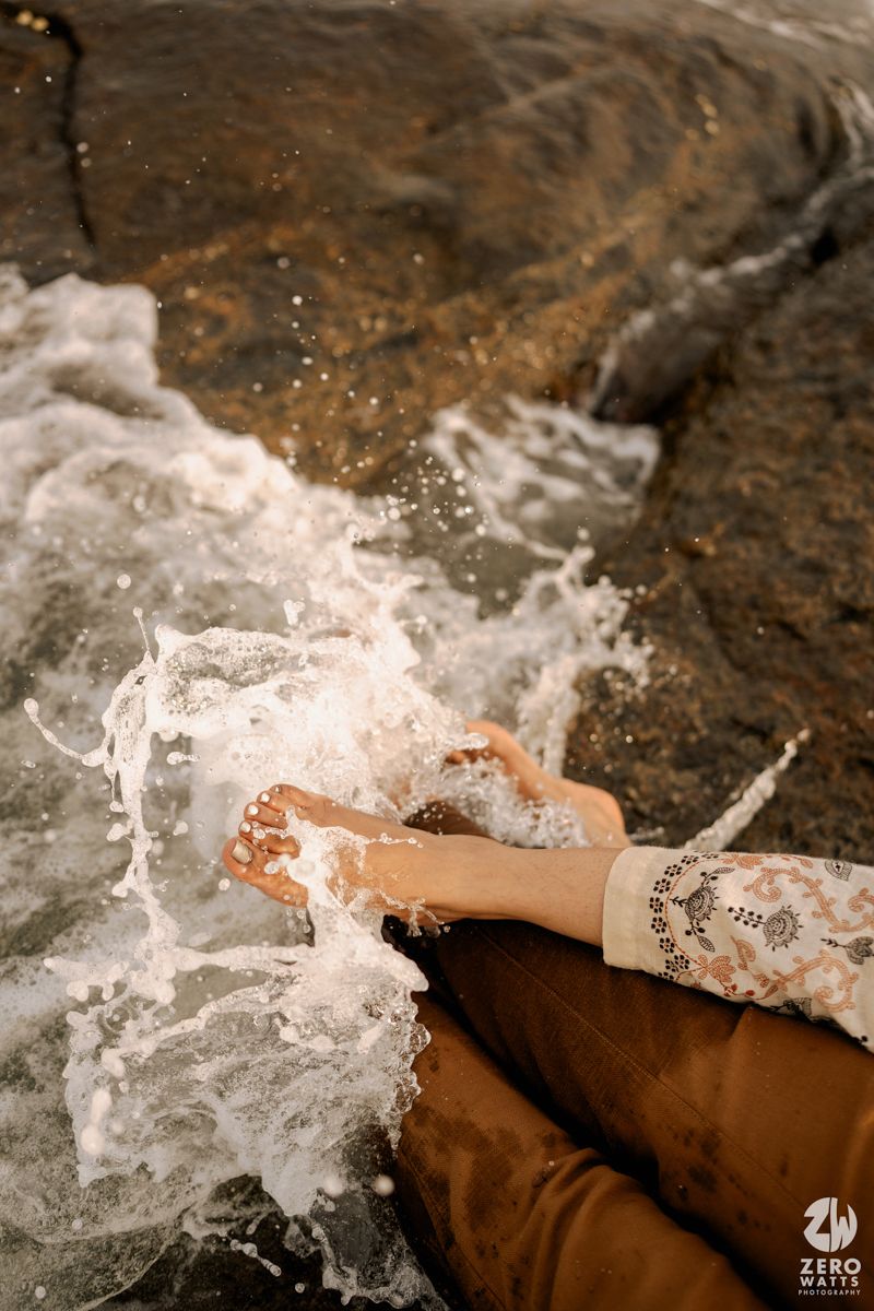 Ocean waves crash and splash against rocks creating a dynamic water spray effect.