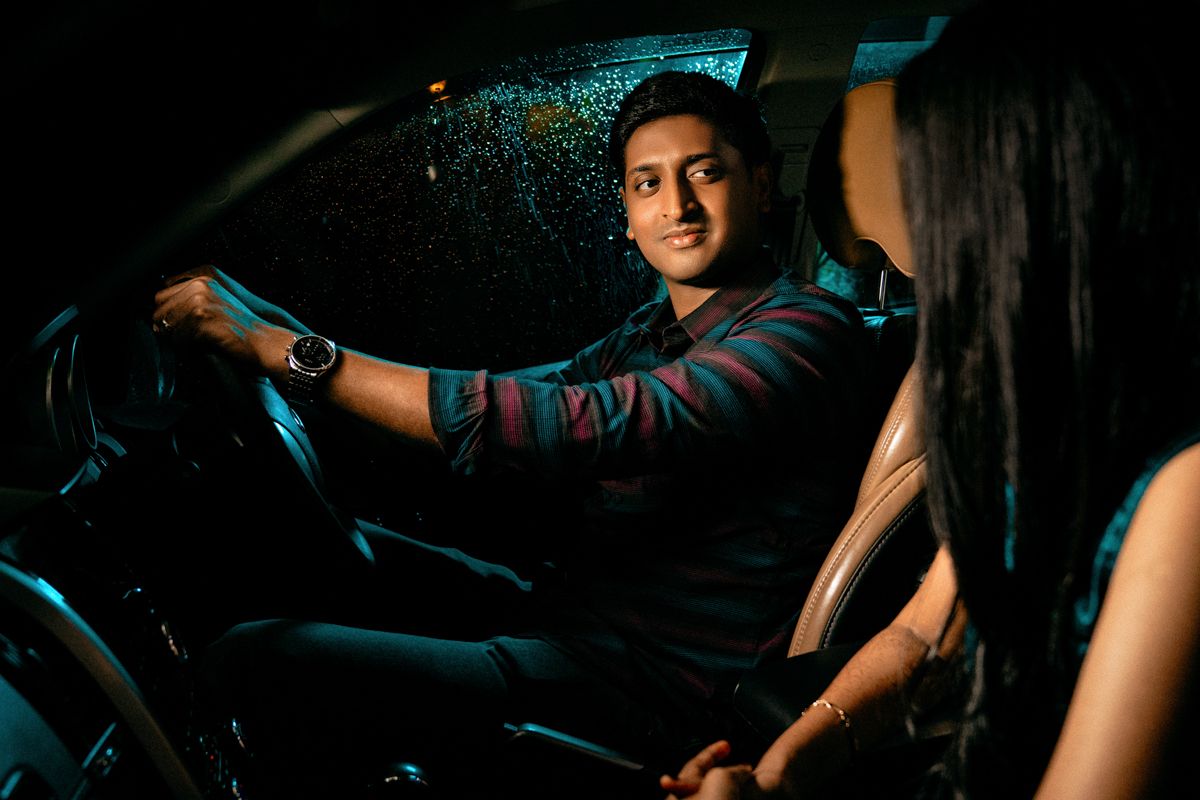 Moody nighttime portrait showing two people in dramatic lighting and shadows.