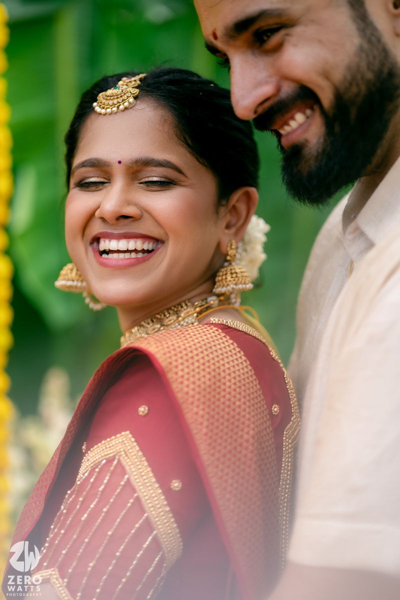 Joyful moments captured during a South Indian wedding with traditional attire and decorative elements.