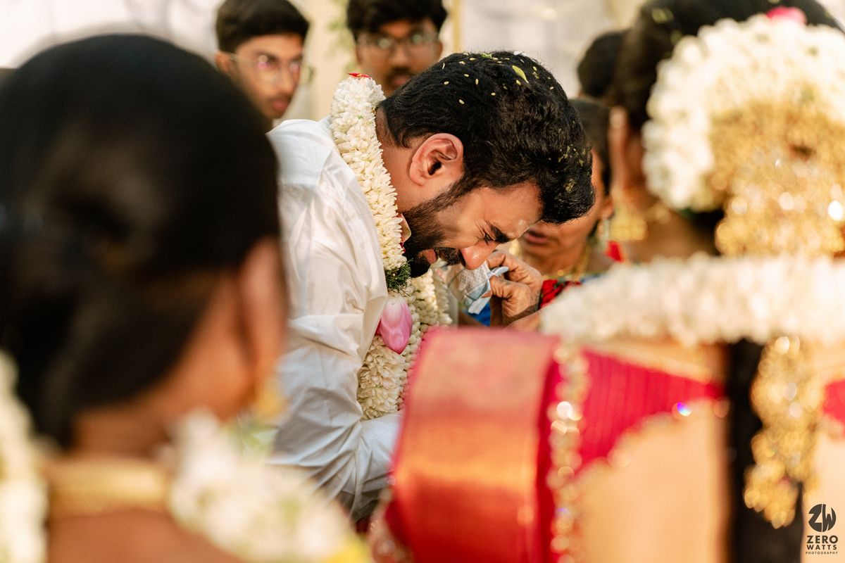 Emotional South Indian groom leaning close to bride during traditional wedding ritual ceremony.