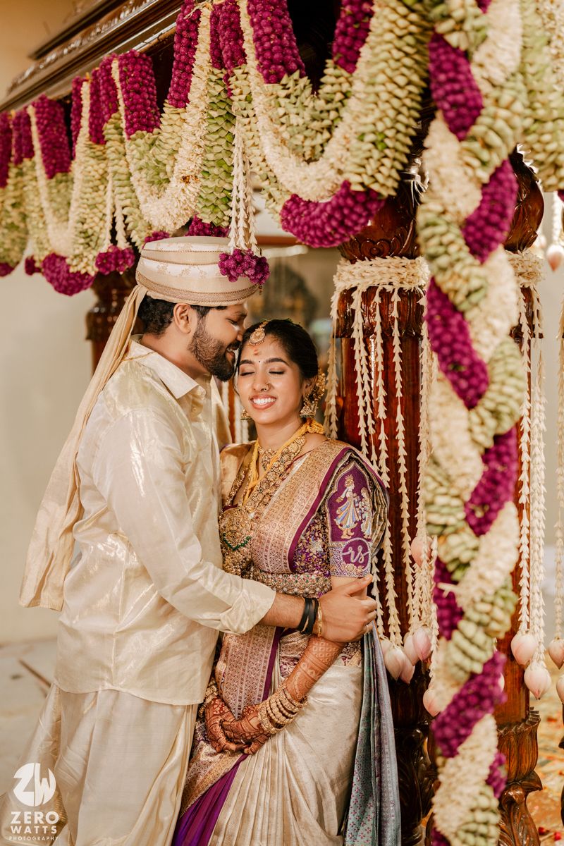 Traditional South Indian wedding ceremony under mandap with pink and white floral decorations.