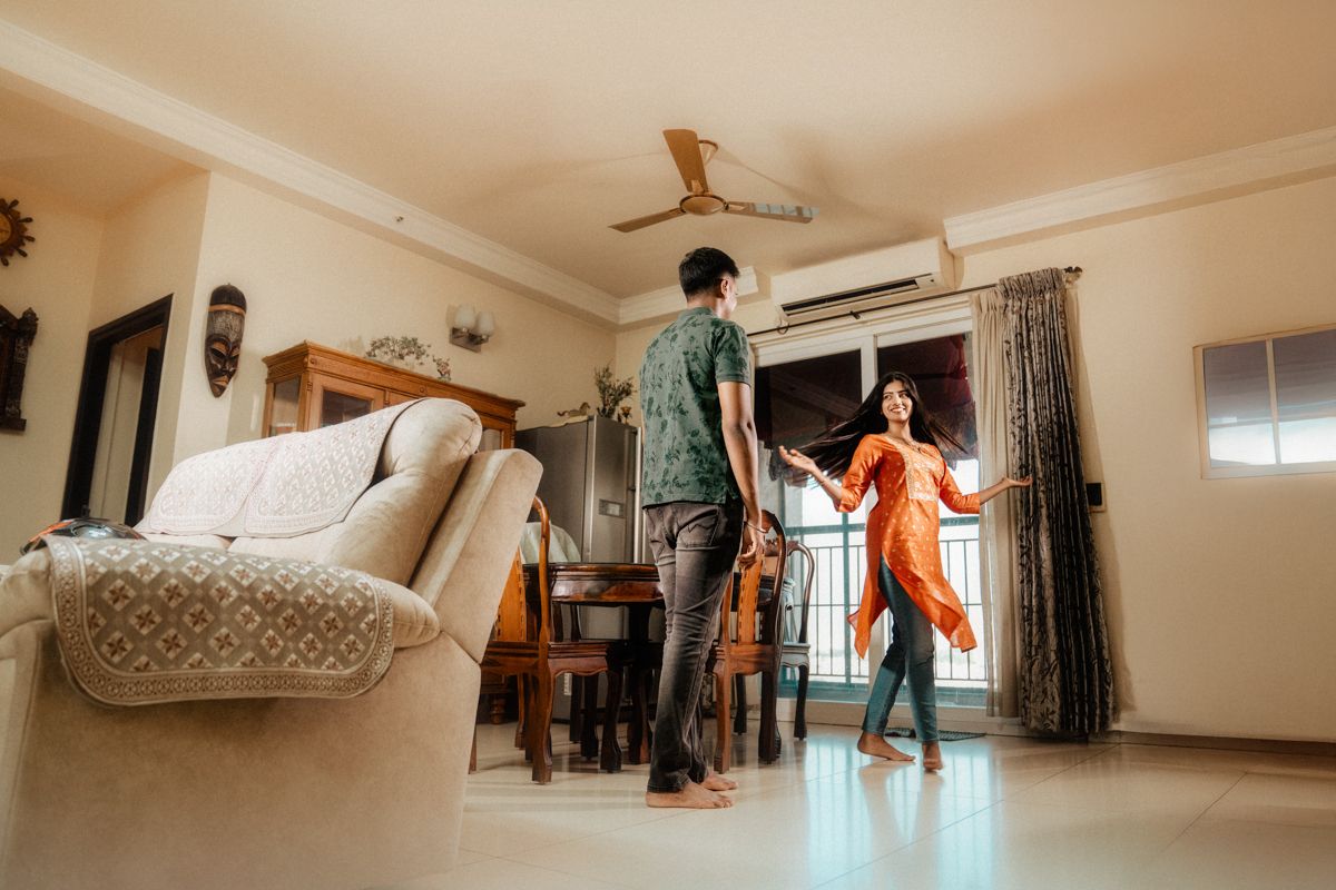 Couple dancing together in a bright living room with modern furniture.