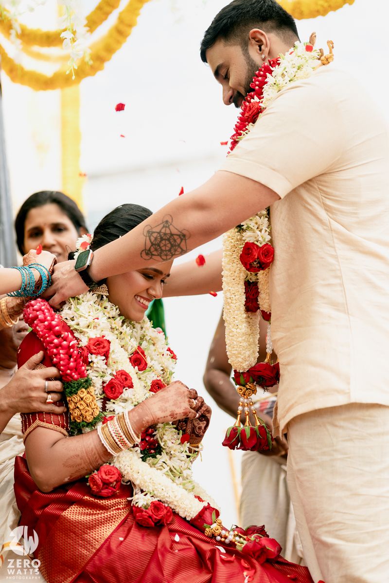 A traditional Indian wedding ceremony showing the exchange of flower garlands during a marriage ritual.