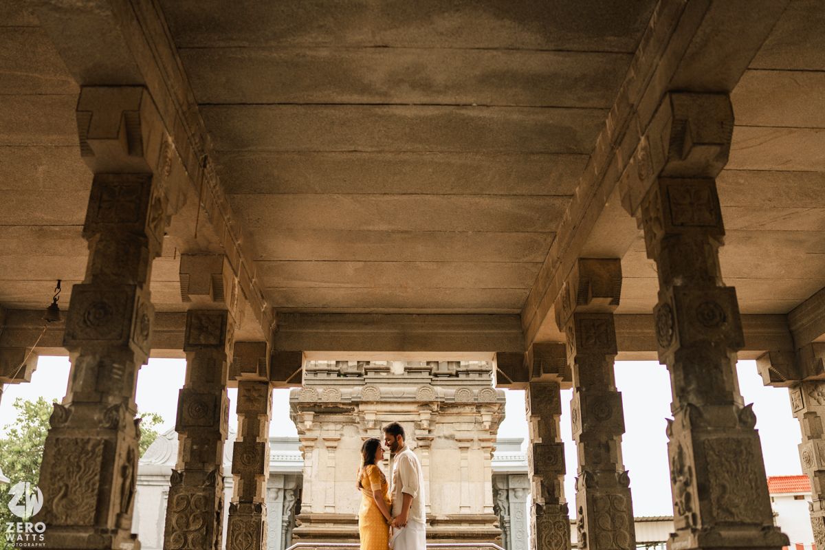 Ancient stone colonnade with arched pillars creating a long covered walkway in warm sunlight.