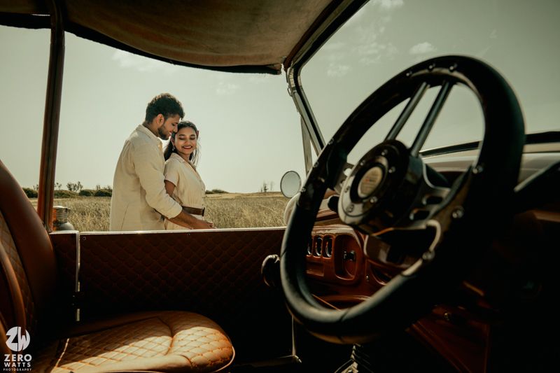 Interior view of classic car dashboard with steering wheel and retro gauges in muted tones.