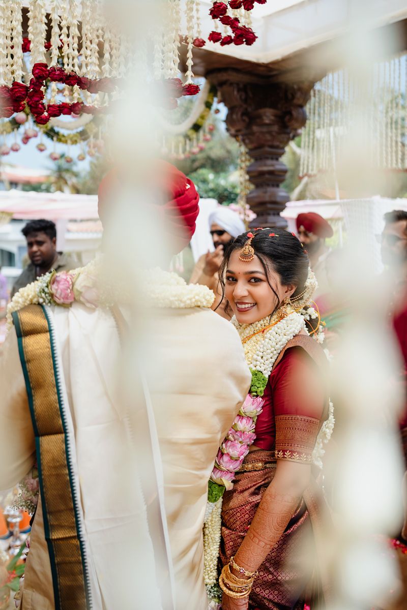 Traditional Indian wedding ceremony setup with hanging crystal decorations and red floral accents.