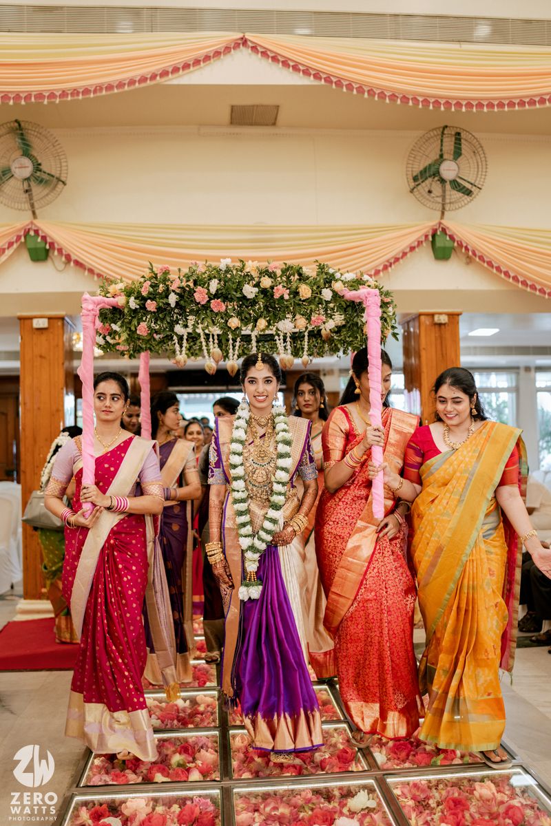 Colorful Indian wedding celebration with women in vibrant sarees under decorated mandap.