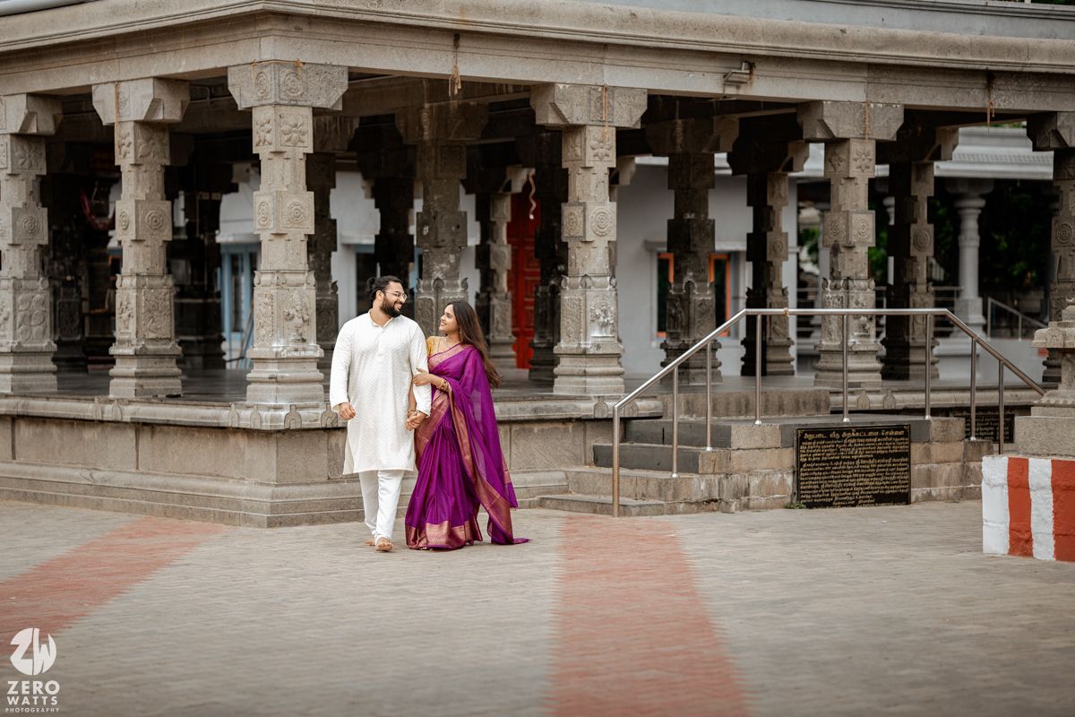 Ancient stone pillars and walkway of a traditional temple courtyard with visitors exploring the historic architecture.