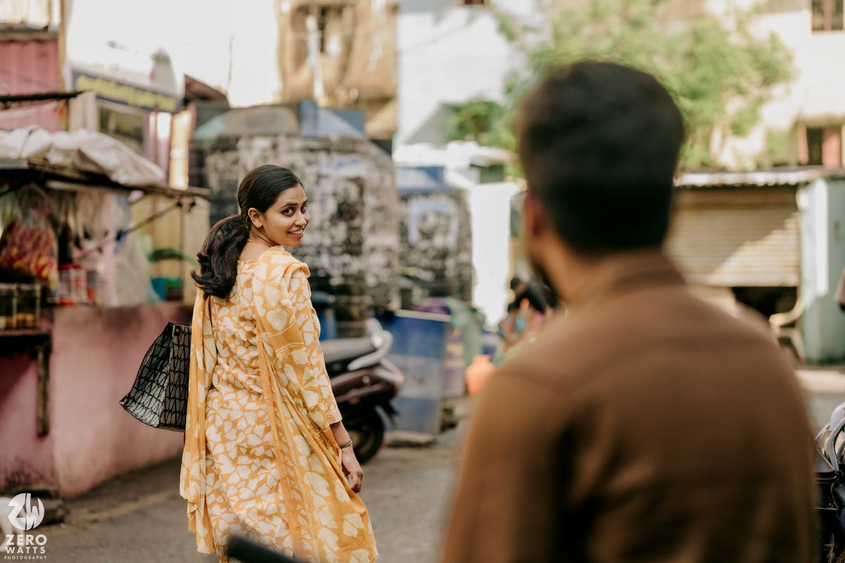 A couple walks down a street while having an animated conversation.