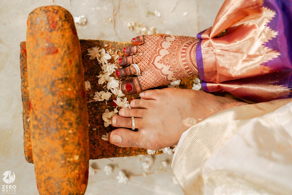 Decorated feet with anklets and henna during traditional Indian wedding ritual.