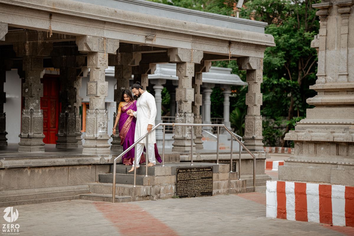 Stone temple architecture with pillars and walkways creates a traditional South Indian architectural scene.