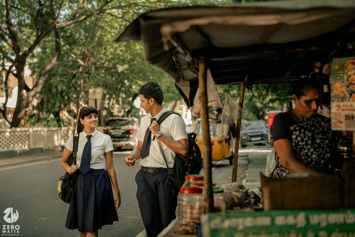 Students walking together on a tree-lined campus pathway during golden hour.