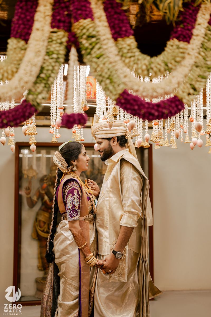 Traditional South Indian wedding ceremony with ornate floral decorations and hanging lights creating a romantic ambiance.