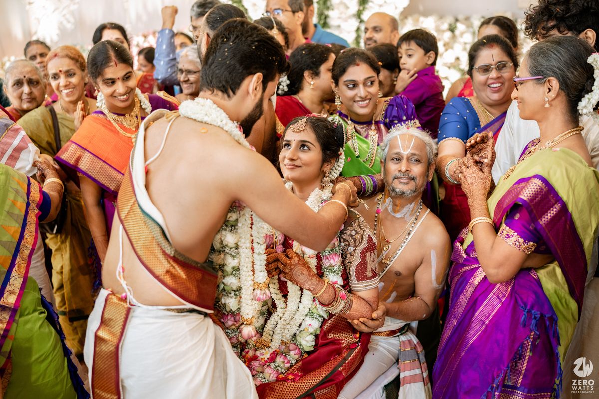 Joyous celebration during an Indian wedding with guests in vibrant traditional attire.