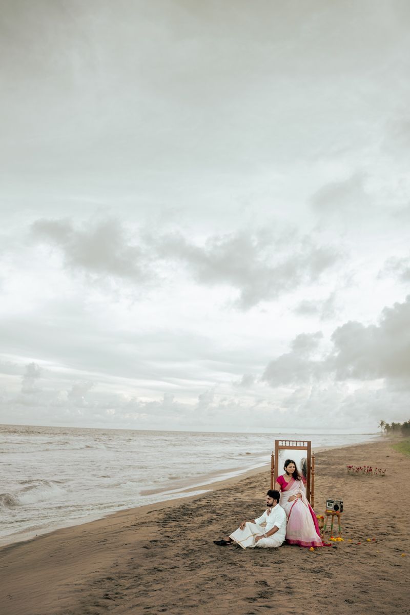 A scenic beach landscape with wooden furniture and cloudy skies stretches along the shoreline.