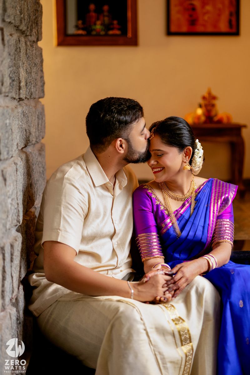 A romantic couple shares tender moments while seated on indoor stone steps.