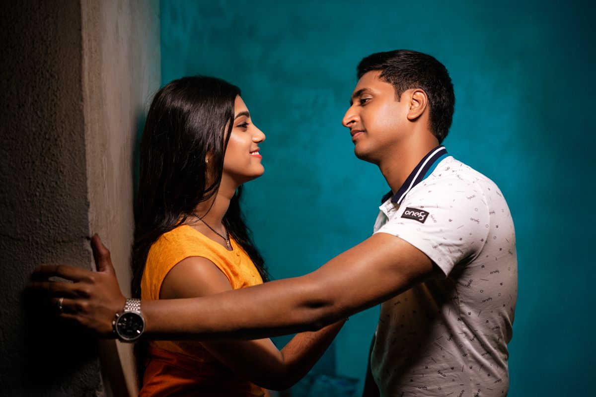 Dramatic scene against turquoise wall showing emotional interaction between two people.