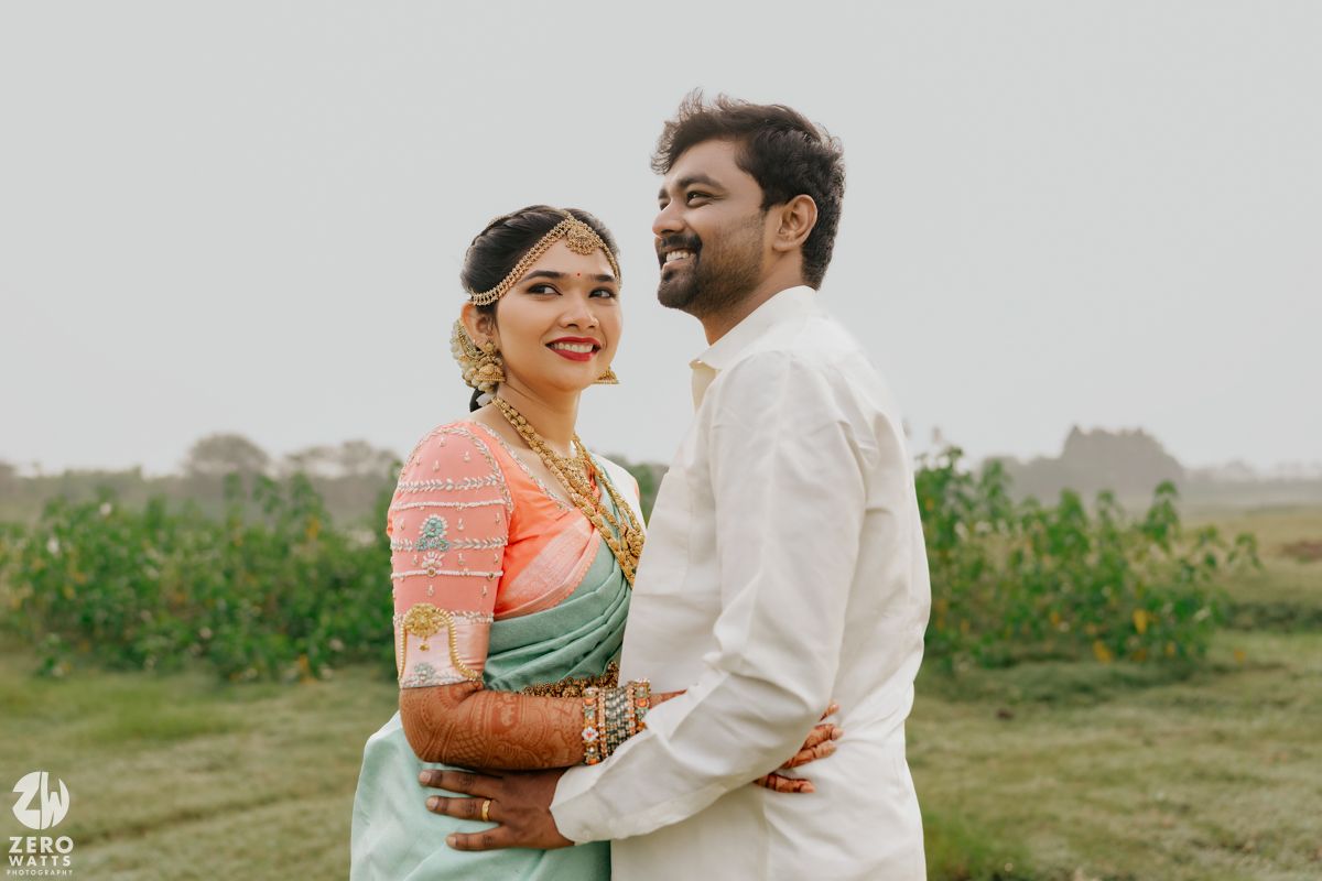 South Indian couple in traditional attire share a romantic moment outdoors during their wedding photoshoot.