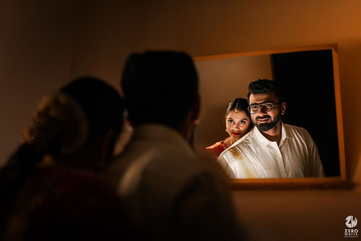 Couple sharing intimate mirror reflection moment during South Indian wedding getting ready ceremony.