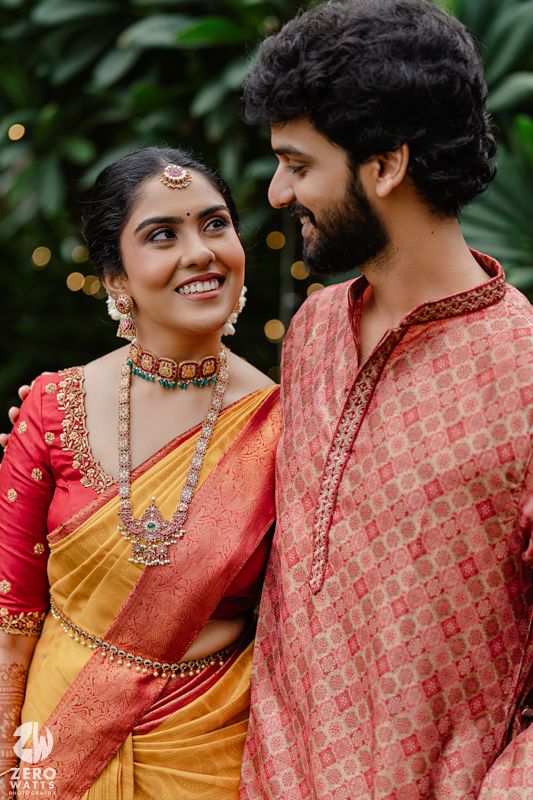 Traditional Indian wedding couple shares intimate moments in colorful attire with detailed jewelry and decorations.