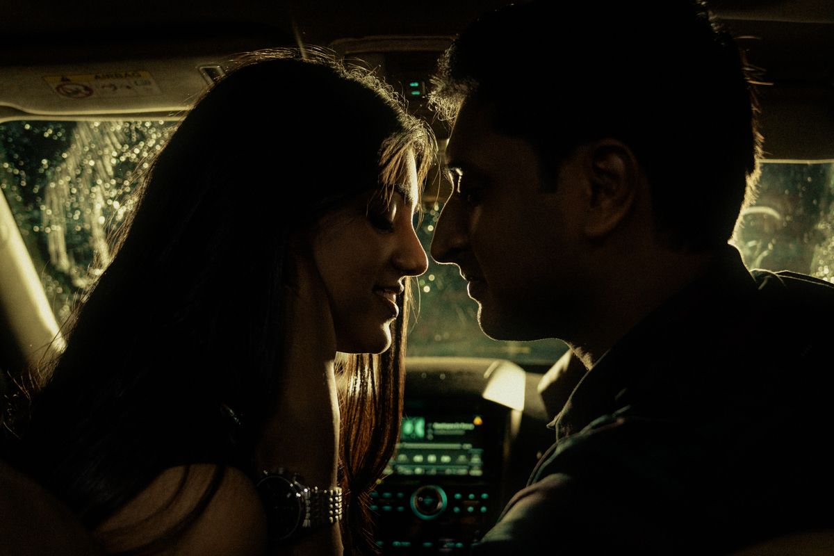 Silhouetted figures in car interior with dashboard lights visible.