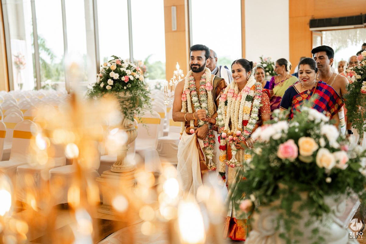 Elegant indoor wedding ceremony setup with floral arrangements and glowing candles.
