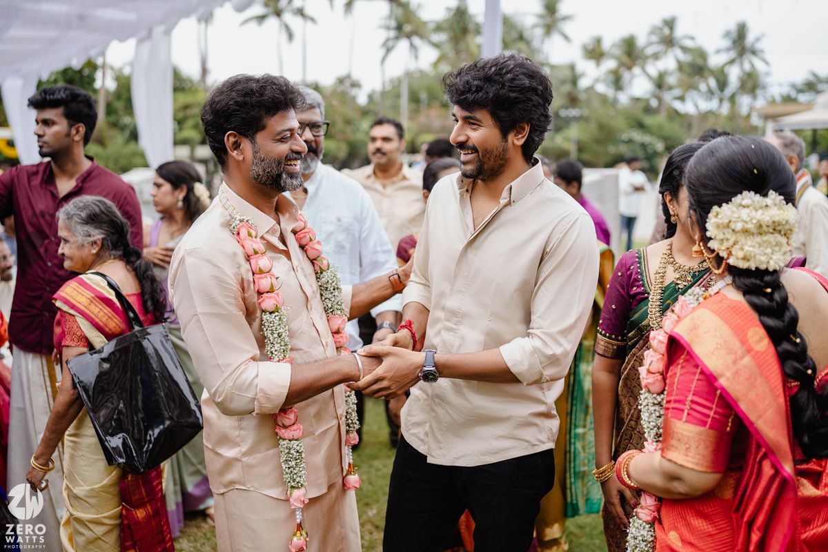 Wedding guests and family members gather outdoors for celebrations in traditional Indian formal wear.