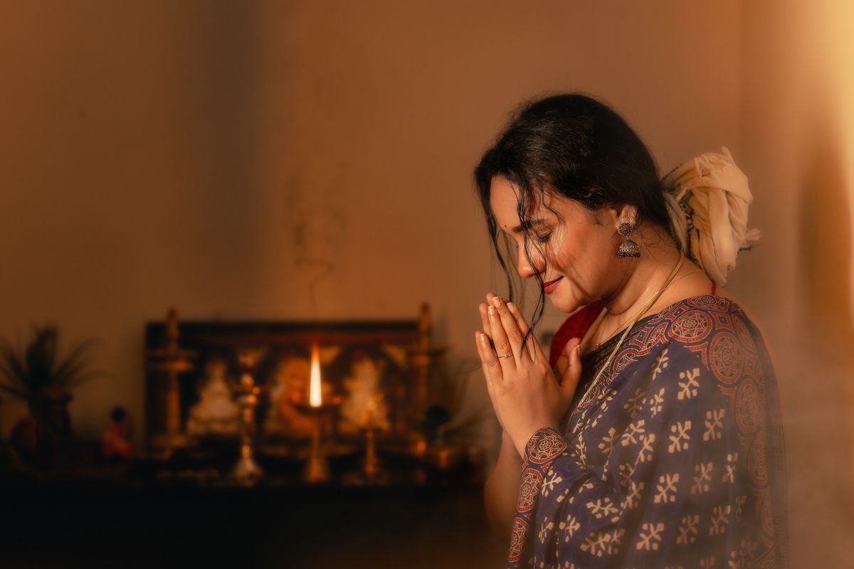 A person in a patterned dress sits in warm lighting creating a romantic ambiance.