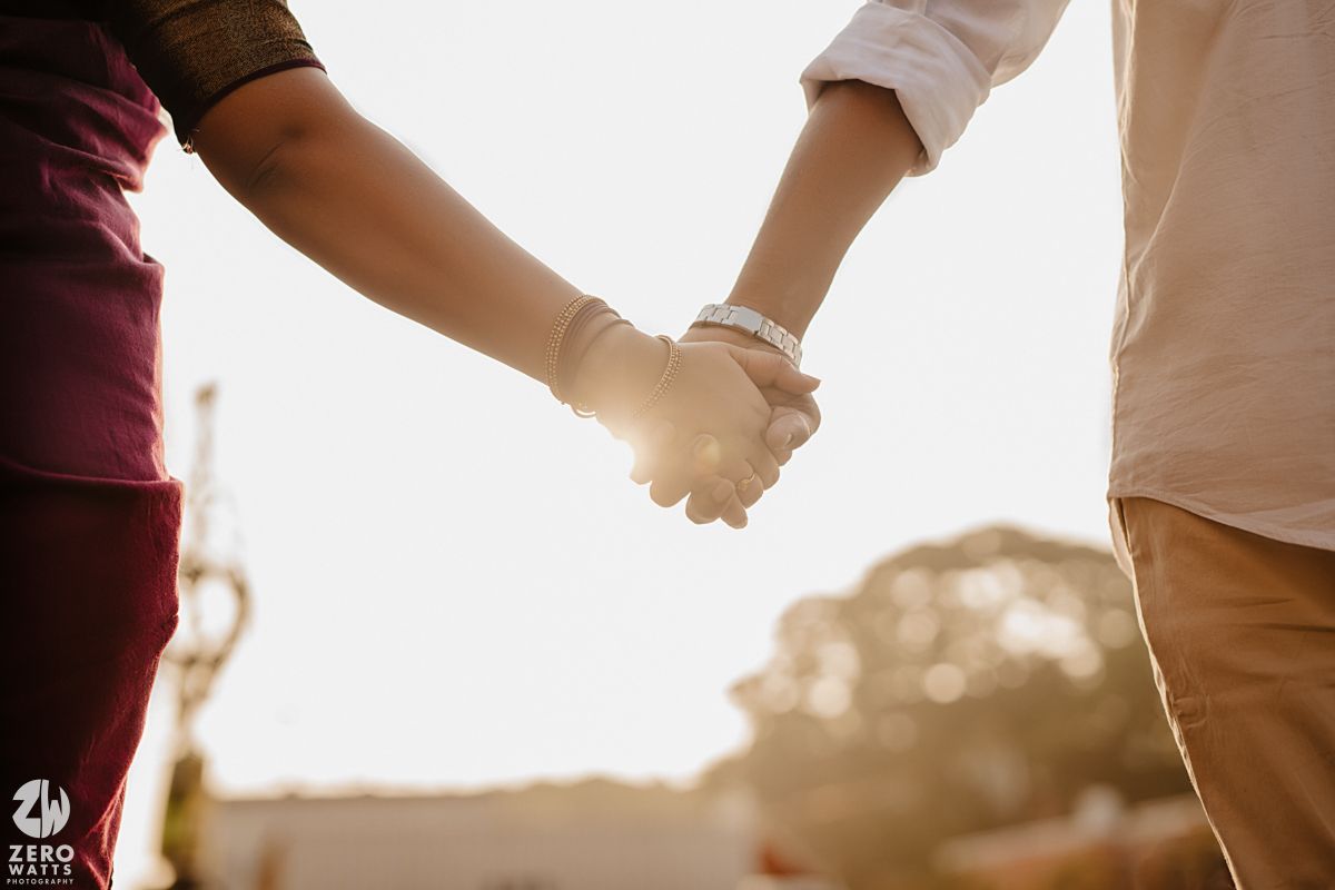 Silhouetted hands joined together in a circle against bright sunlight creating a unity and connection concept.